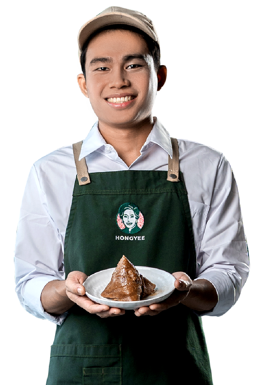 A HONGYEE team member holding a freshly wrapped kuih chang